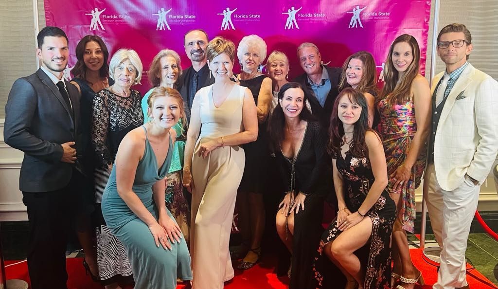 A group of people are posing for a picture on a red carpet.
