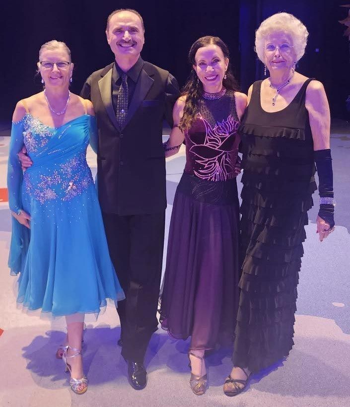 A group of people posing for a picture on a dance floor