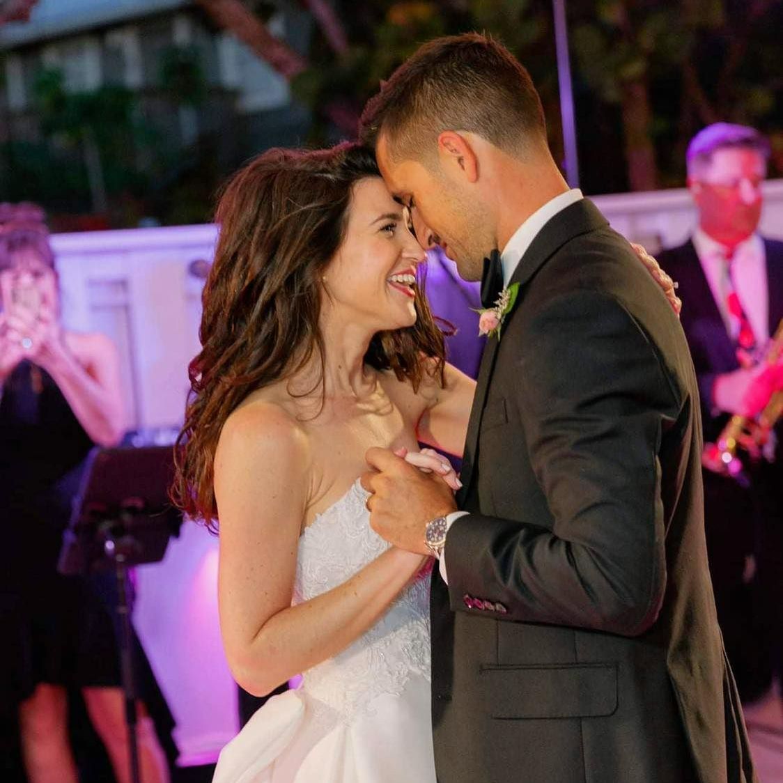 A bride and groom are dancing together at their wedding reception.