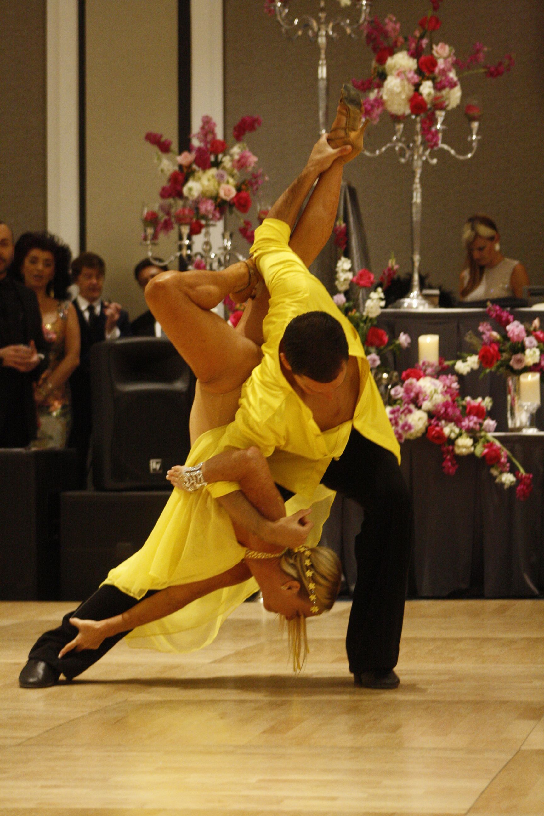 A man and a woman are dancing on a dance floor