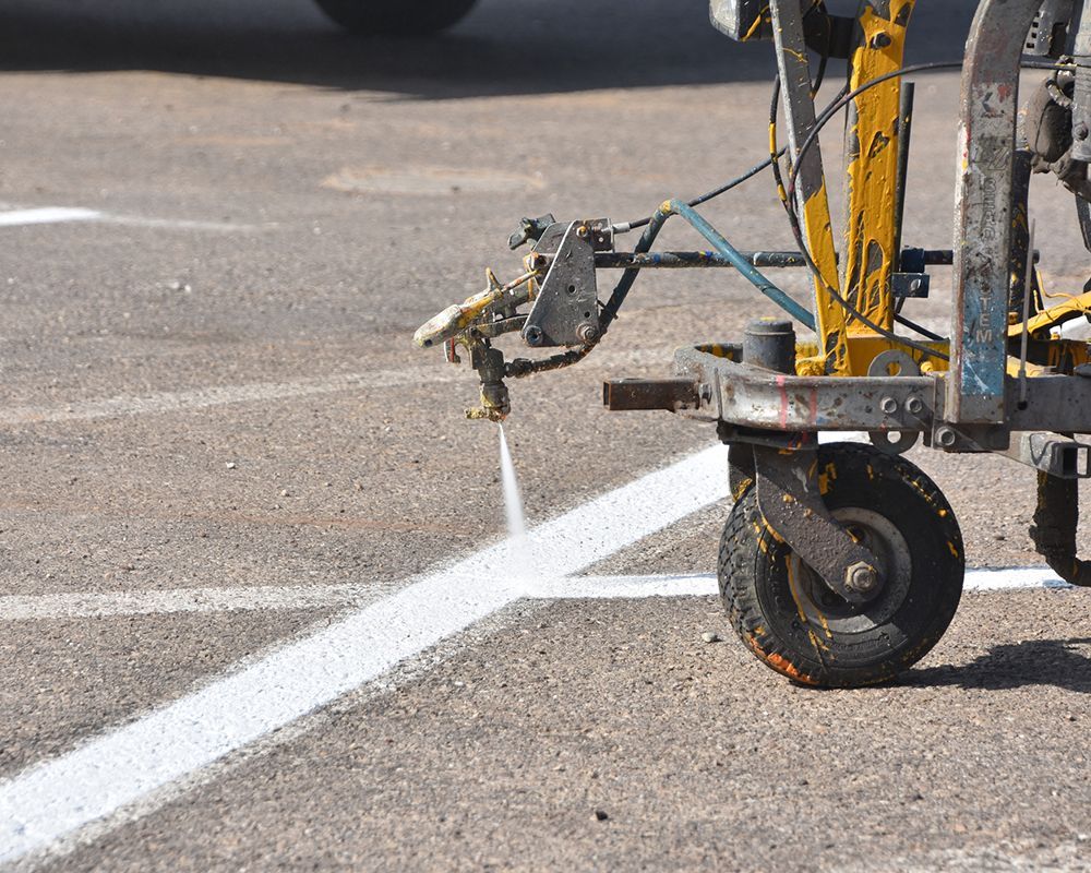 Machine is Spraying Yellow Paint on a Parking – Oahu, HI – Oahu Sealcoating & Paving