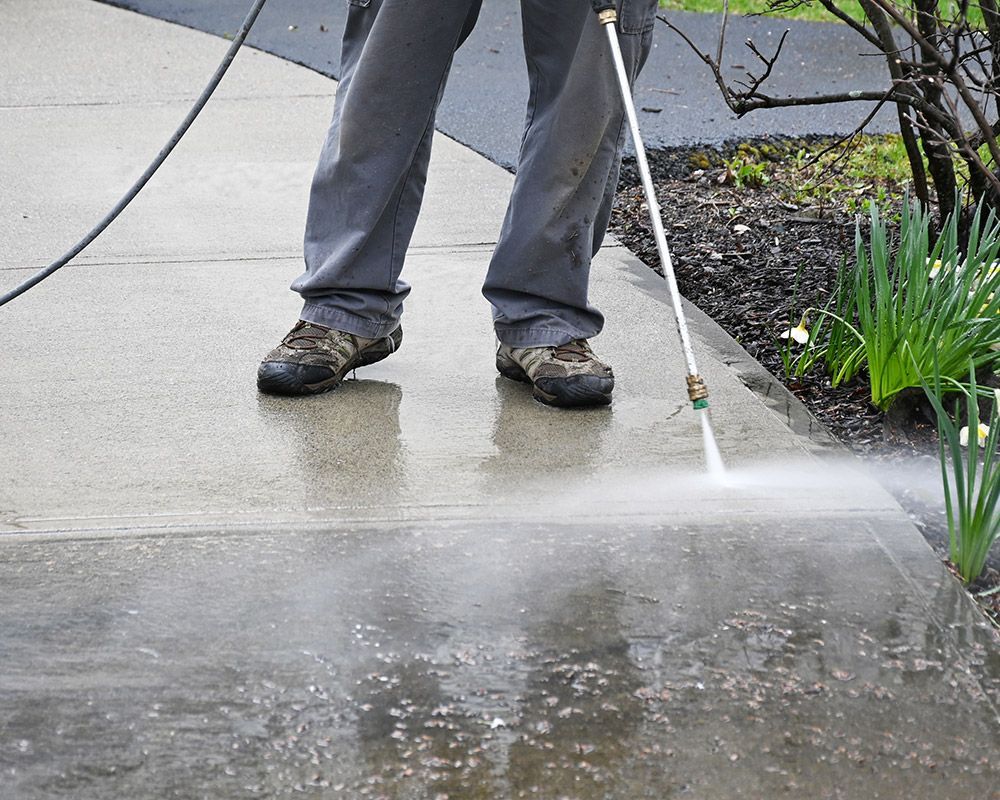 Worker Using Pressure Washer to Clean Sidewalk – Oahu, HI – Oahu Sealcoating & Paving