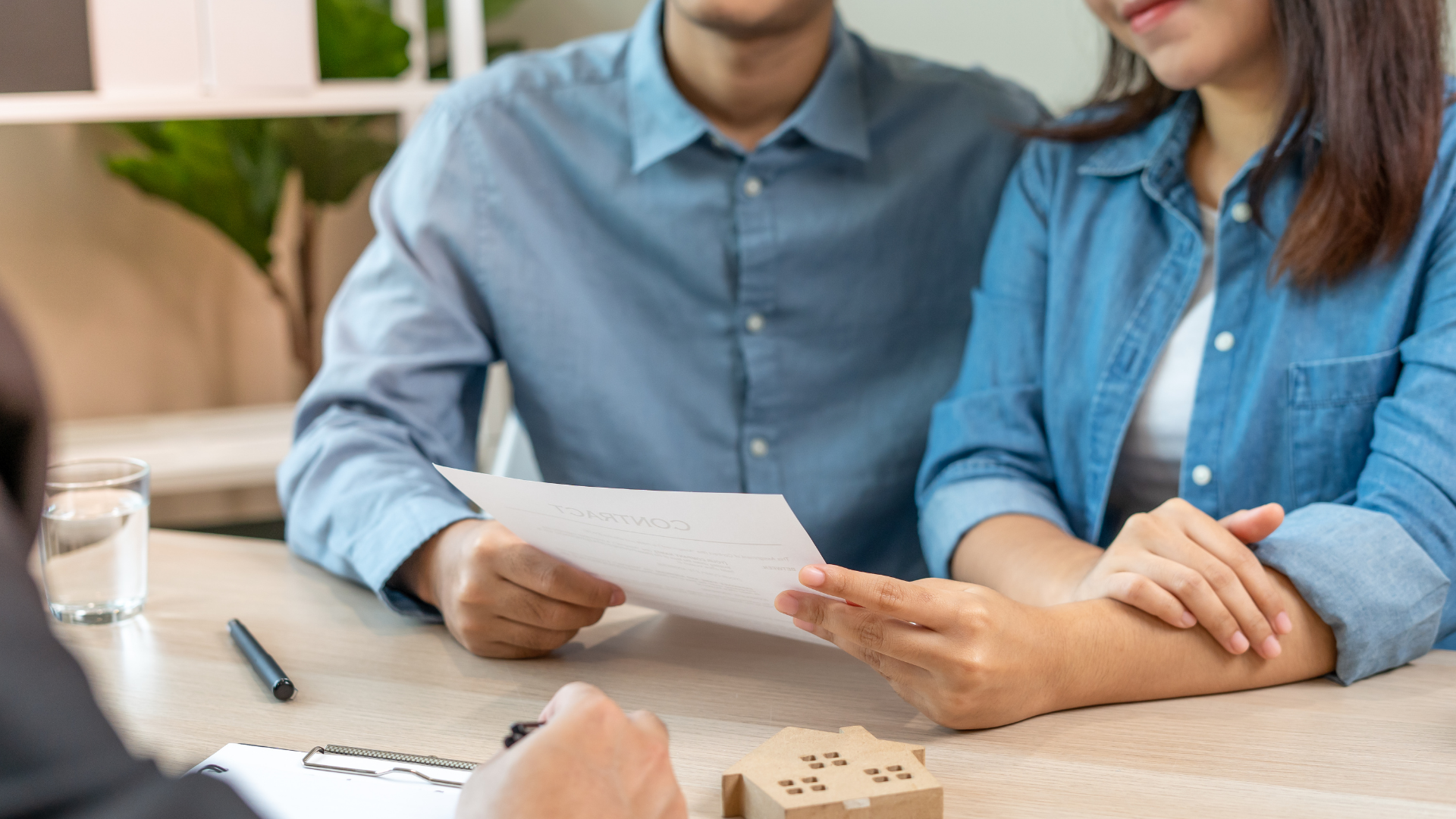 A man and a woman are sitting at a table looking at a piece of paper.