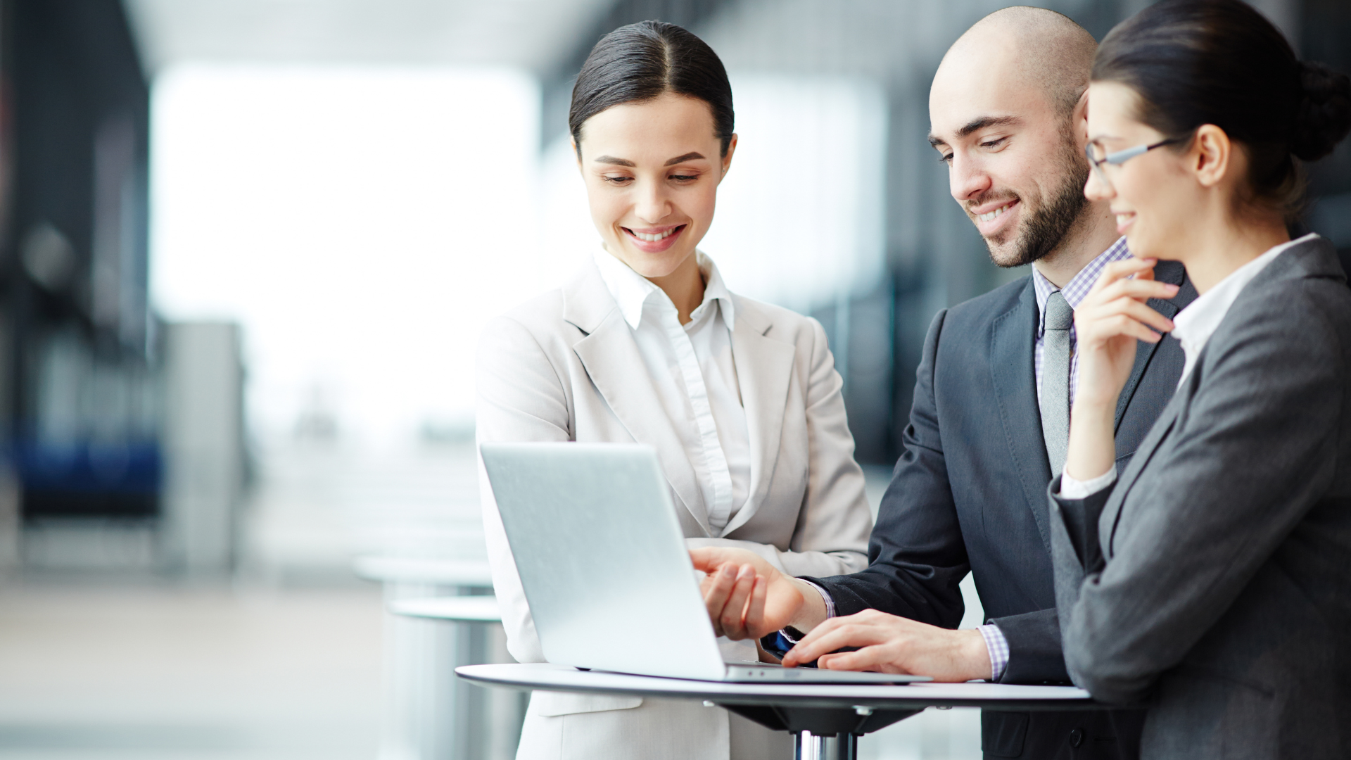 A group of business people are looking at a laptop computer.