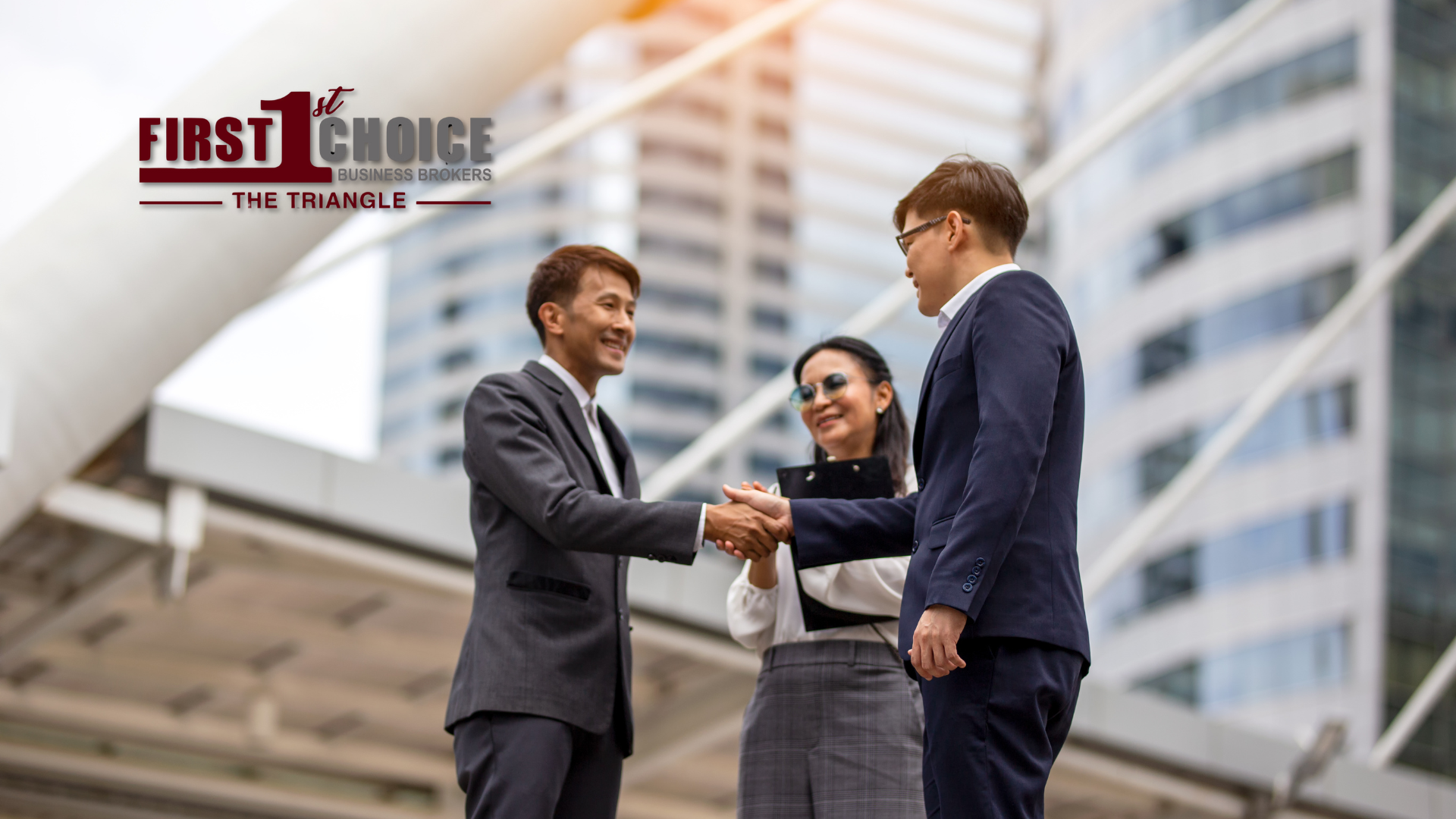 A group of business people shaking hands in front of a building.