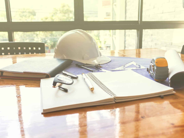 Hard hat and notebook on a desk
