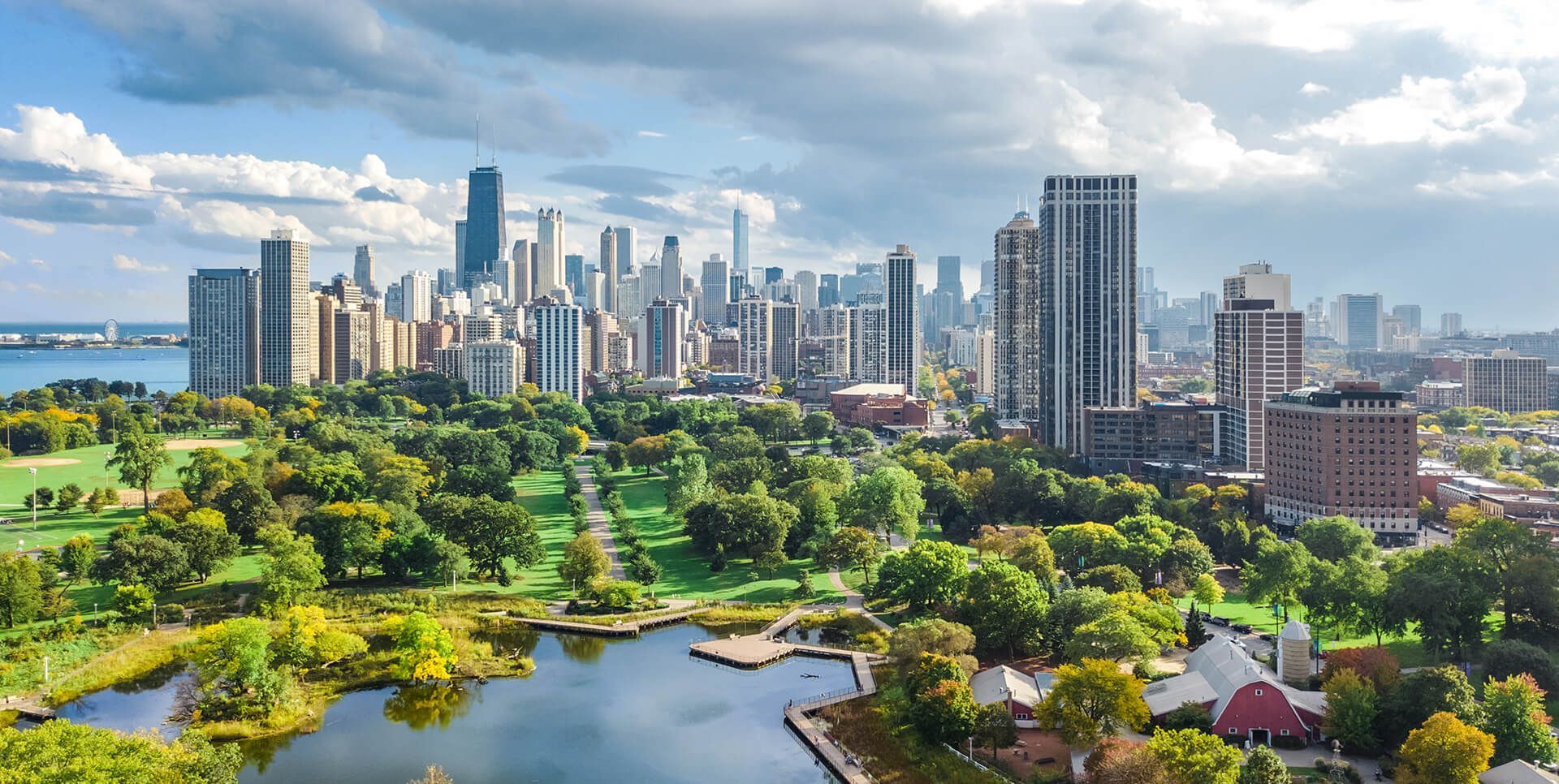 Chicago skyline with park and lake under a cloudy sky.