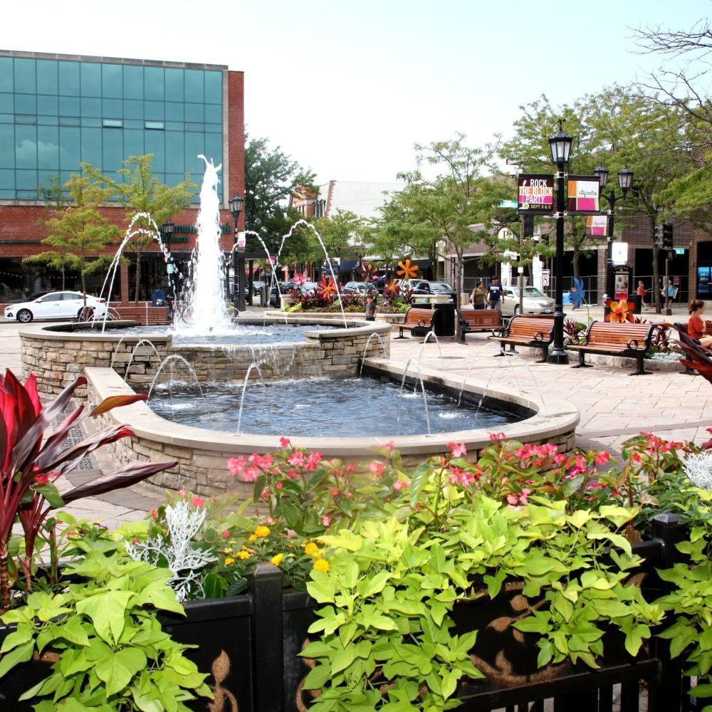Brick building with tower, framed by trees against a bright sky.