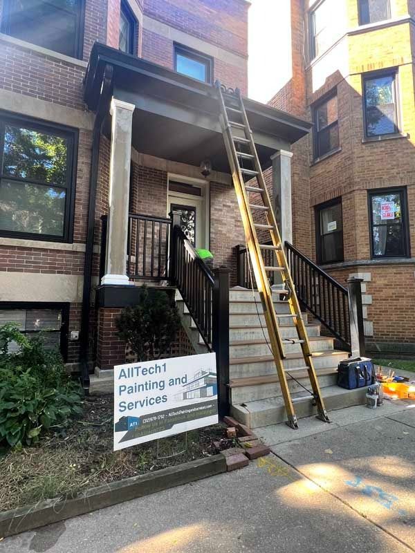 Exterior view of building with a ladder leaning against the porch. Sign: 