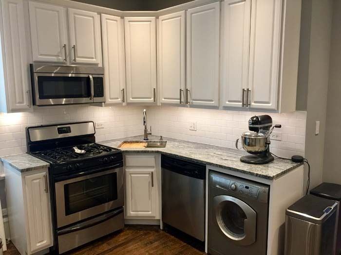 Small kitchen with white cabinets, stainless steel appliances, and gray countertops.