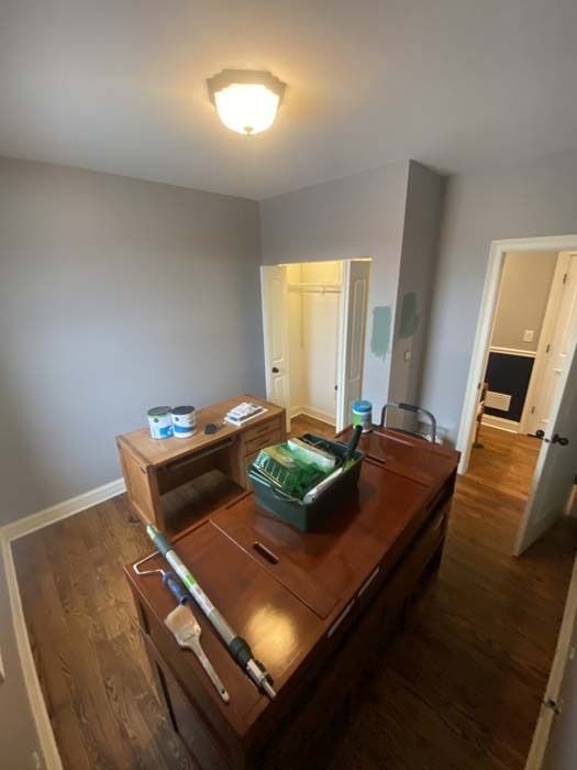 Room with wood furniture, freshly painted gray walls, closet, and open doorways.