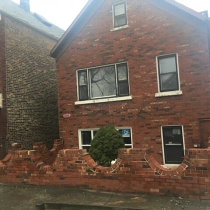 Red brick house with a decorative brick wall in front.