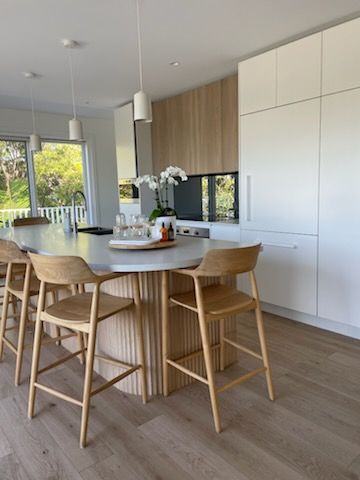 Modern Kitchen With Light Wood Island, White Countertops, and Wood Bar Stools — Gateway Manufacturing in Morisset, NSW