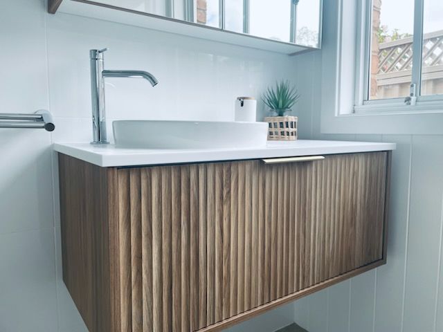 Wooden Vanity With a White Sink and Faucet in a Modern Bathroom With a Window — Gateway Manufacturing in Morisset, NSW
