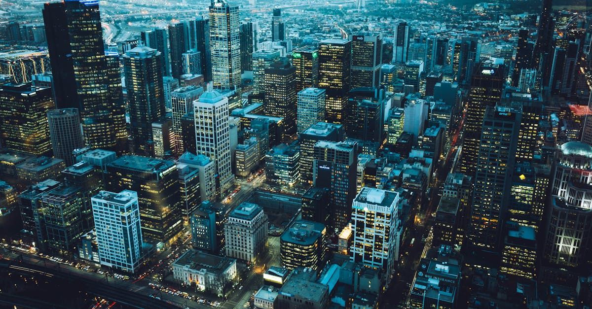 An aerial view of a city at night with lots of buildings lit up.