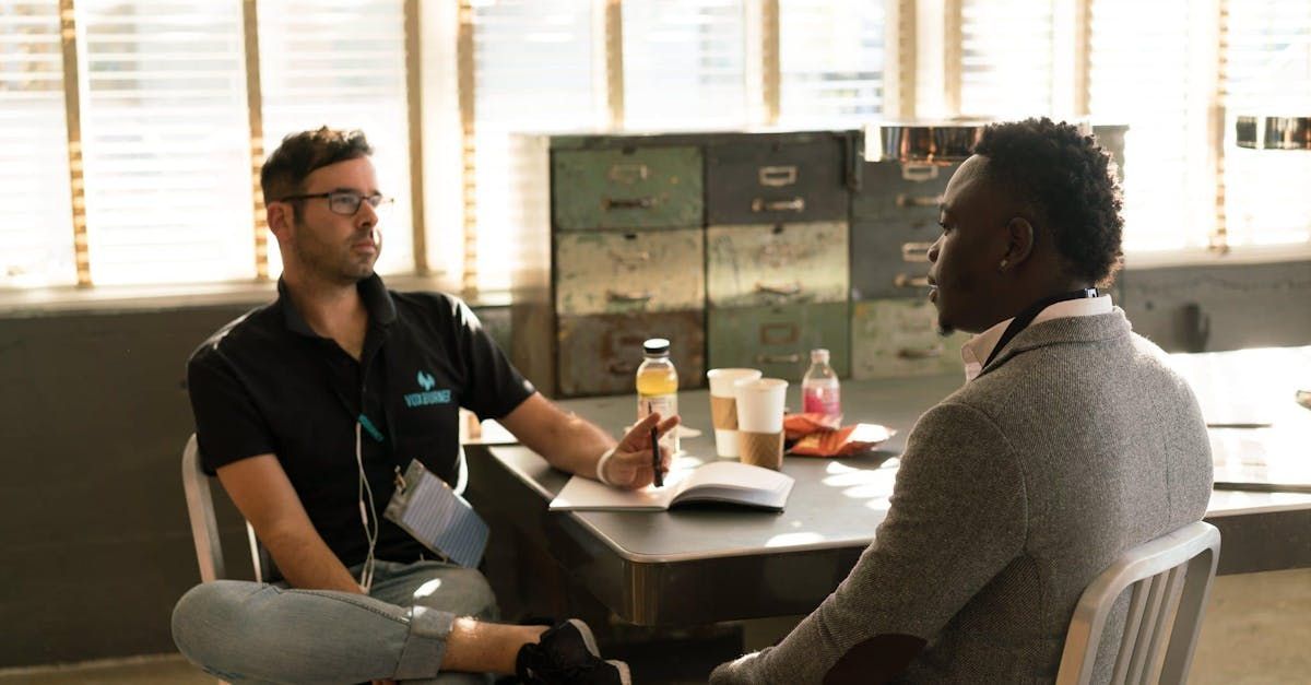 Two men are sitting at a table having a conversation.