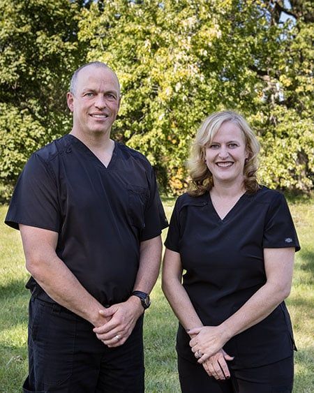 A man and a woman are standing next to each other in a field.