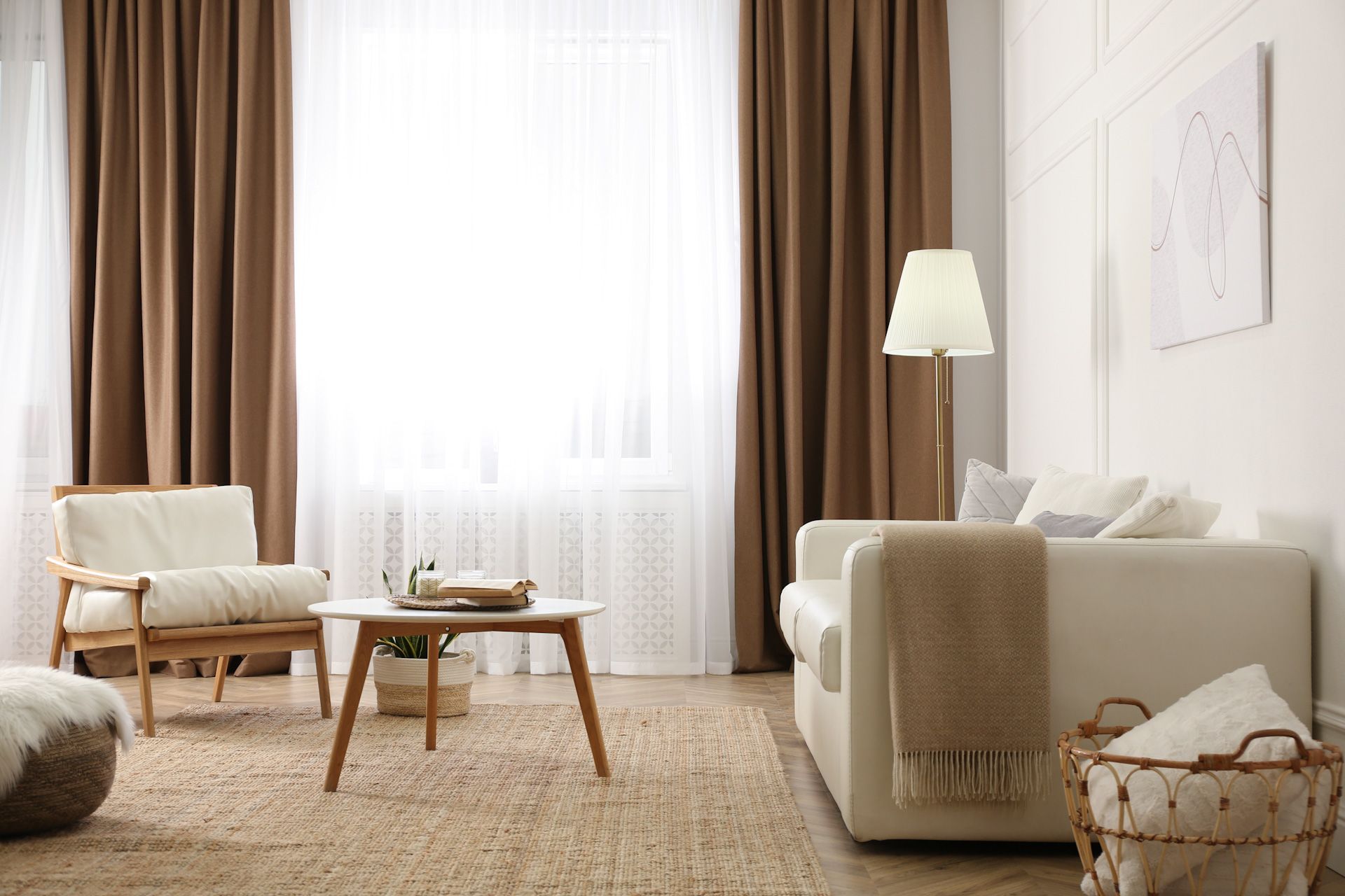A living room with a couch , chair , coffee table and lamp.