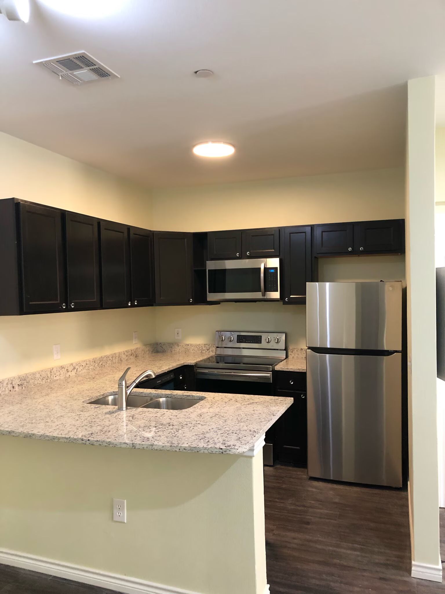 A kitchen with stainless steel appliances and granite counter tops.