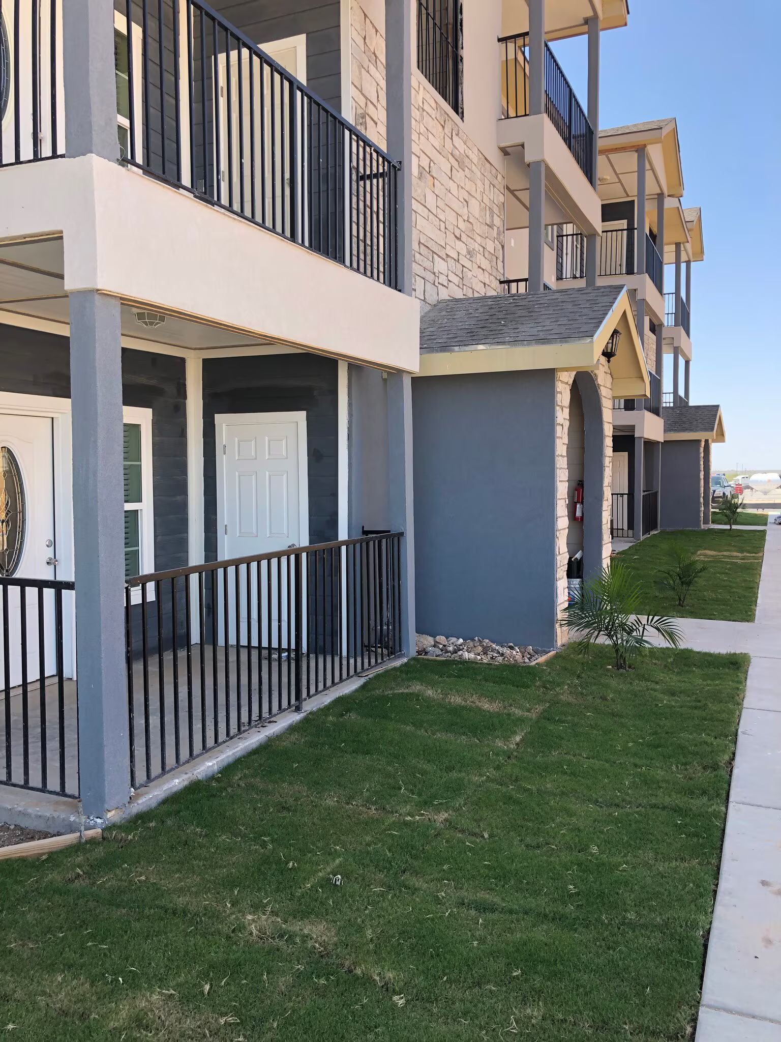 A building with a balcony and a fence in front of it