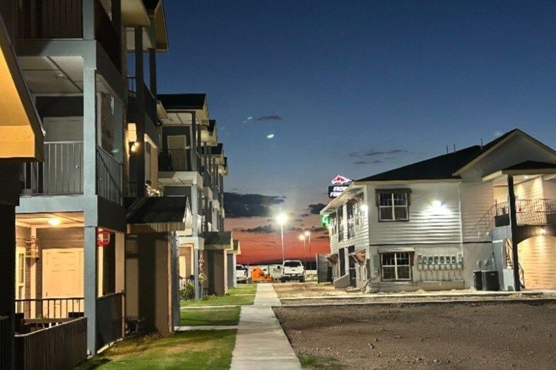 A row of apartment buildings are lit up at night