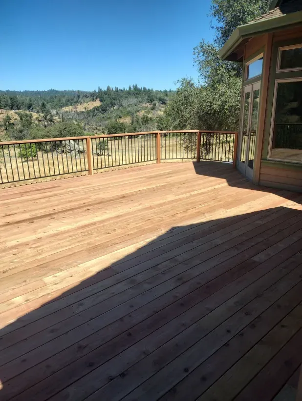 A large wooden deck with a view of a valley