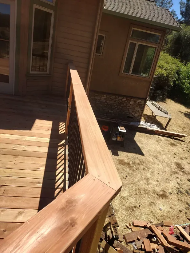 A wooden deck with a house in the background