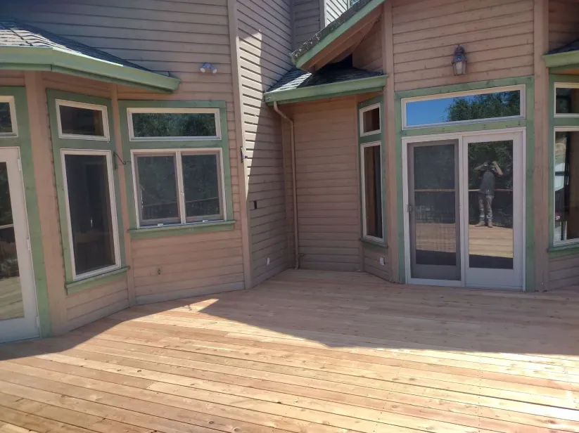 A large house with a wooden deck in front of it.