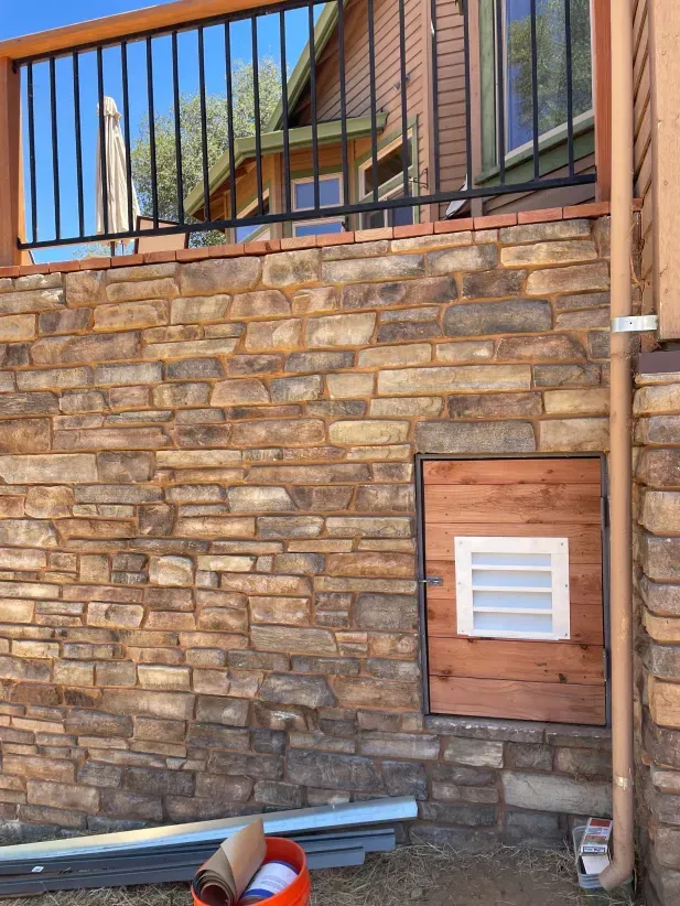 A brick wall with a window and a drainpipe on it