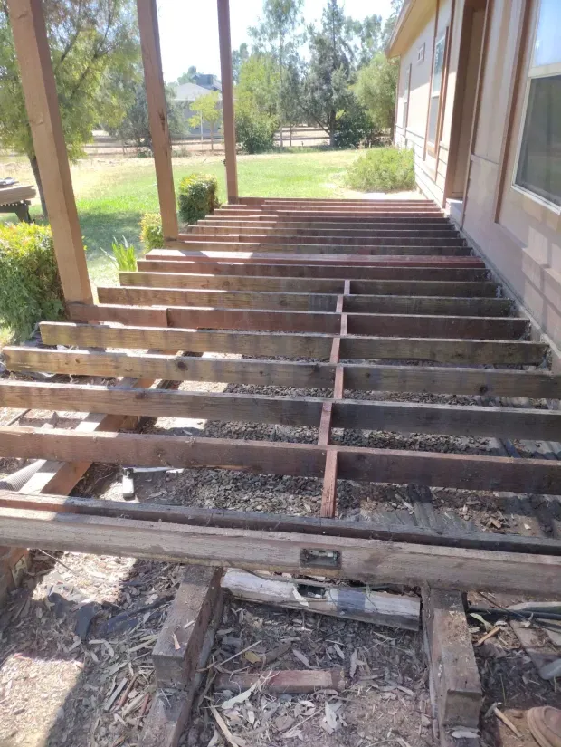 A wooden deck is being built on the side of a house.