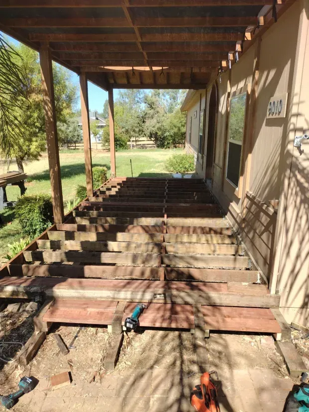 A wooden deck is being built on the side of a house.