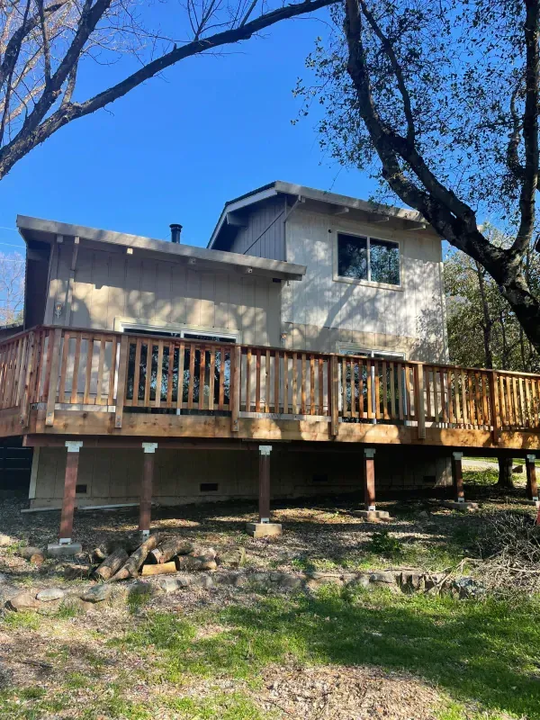 A house with a large wooden deck in front of it