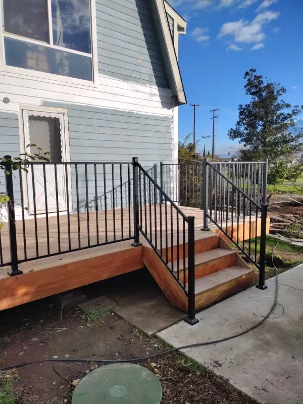 A wooden deck with stairs and a metal railing