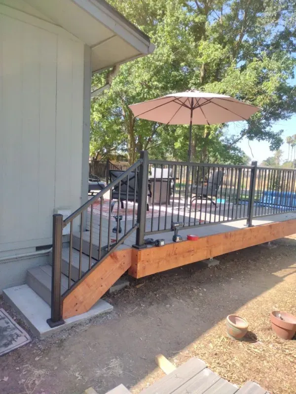 A deck with stairs and an umbrella on it