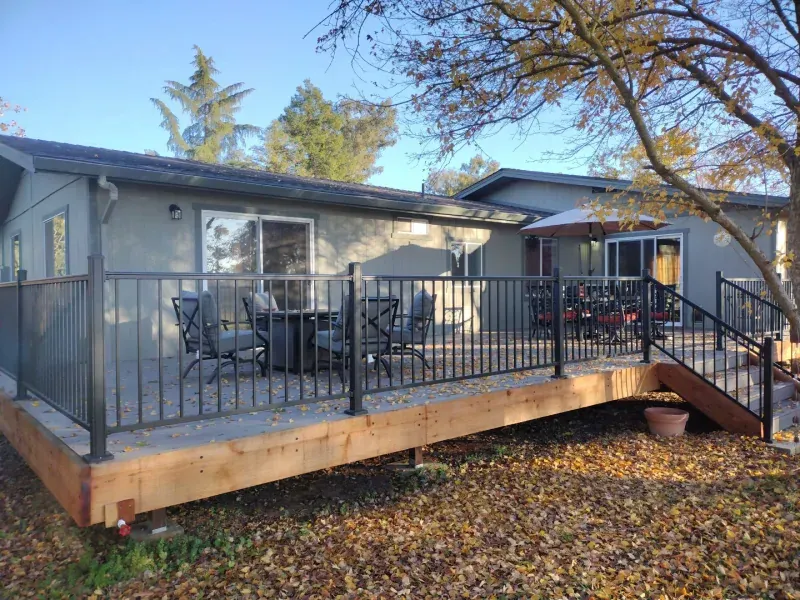 A house with a large deck and stairs in front of it.