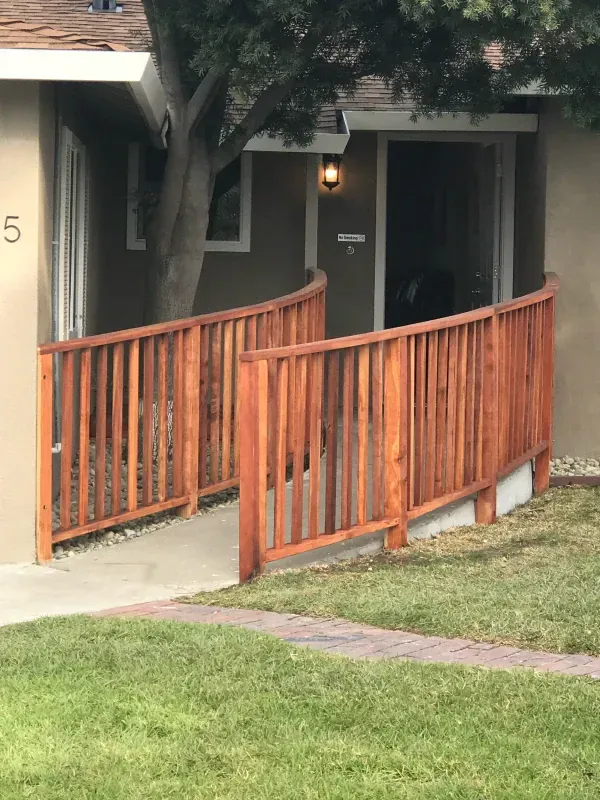 A wooden fence with a ramp leading to a house
