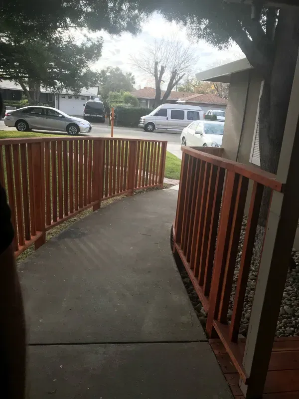 A ramp with a wooden railing leading to a house