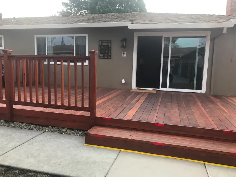 A house with a wooden deck and sliding glass doors
