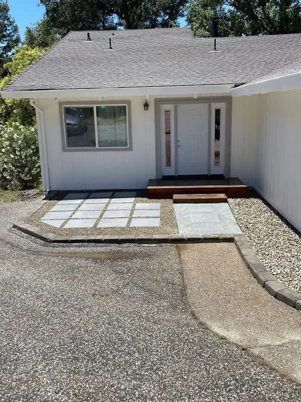 A white house with a walkway leading to the front door