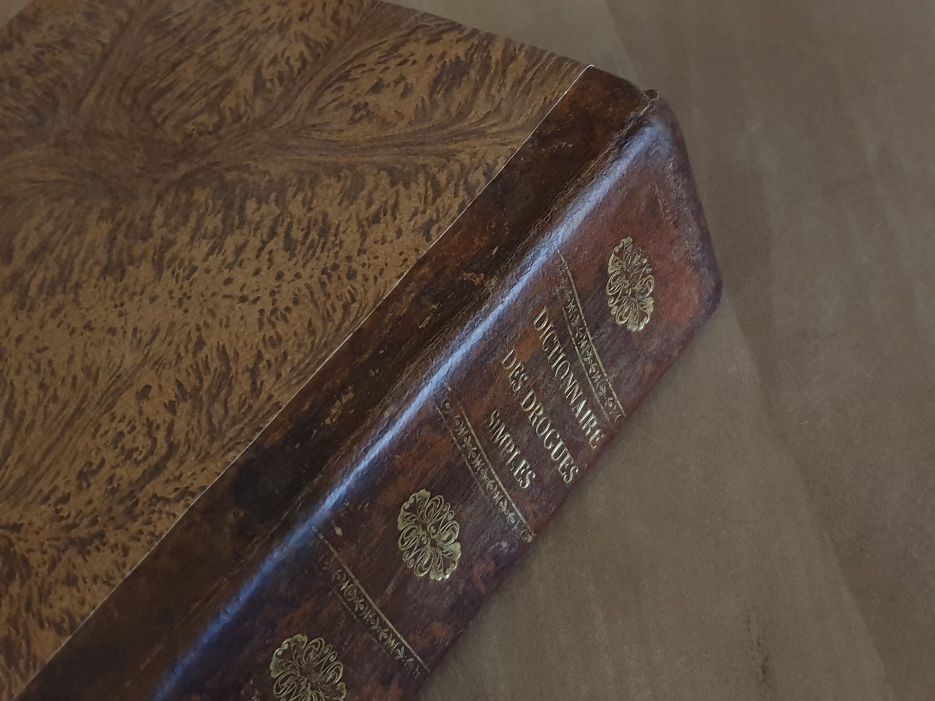 Un vieux livre est posé sur une table en bois.