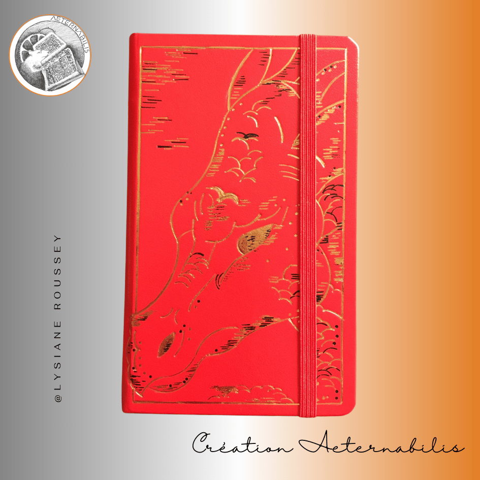 Un livre rouge avec une feuille d'or sur la couverture s'intitule Création Éternabilia