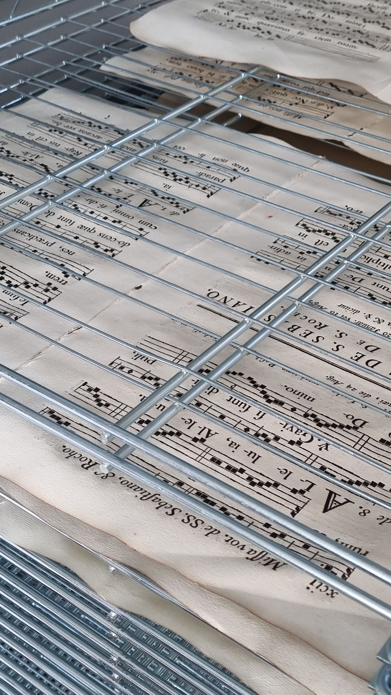 Un tas de partitions est posé sur un support en métal.