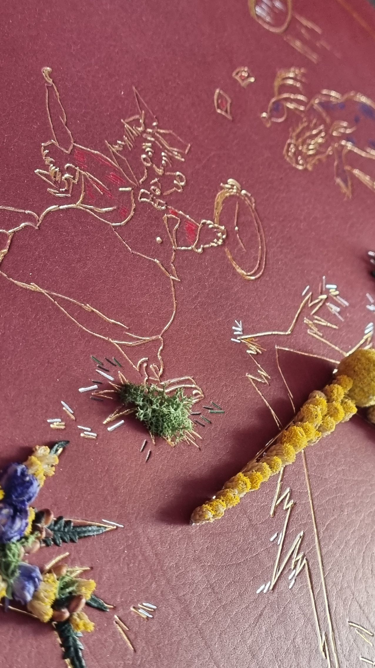 Un gros plan d'un dessin d'une libellule sur une surface rouge.