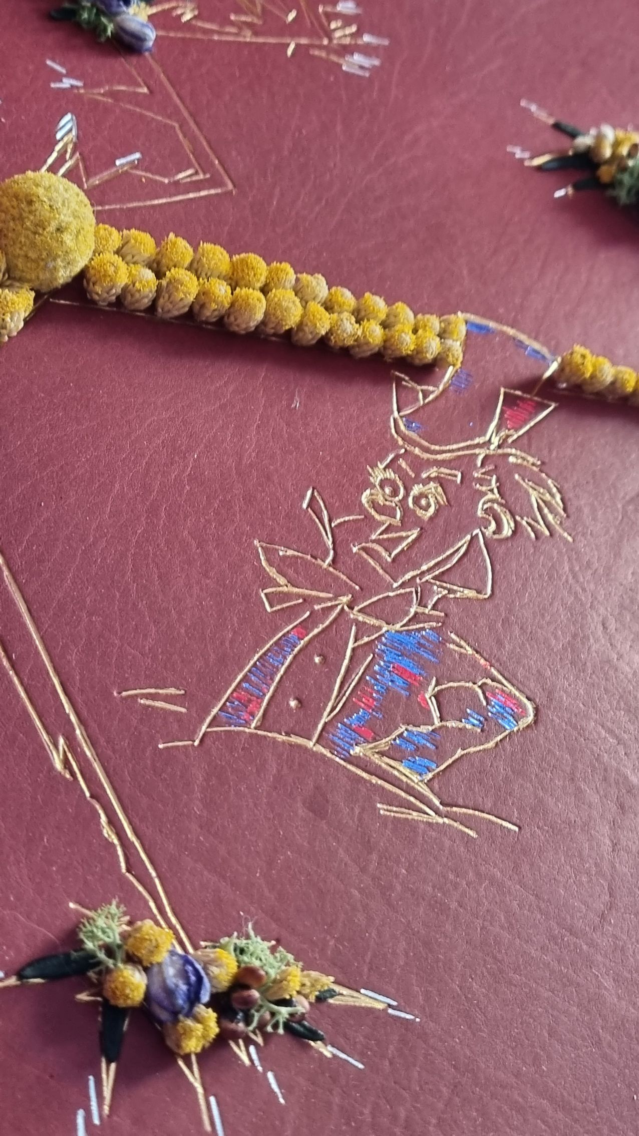 Un gros plan d'un collier avec des perles jaunes sur une surface rouge.