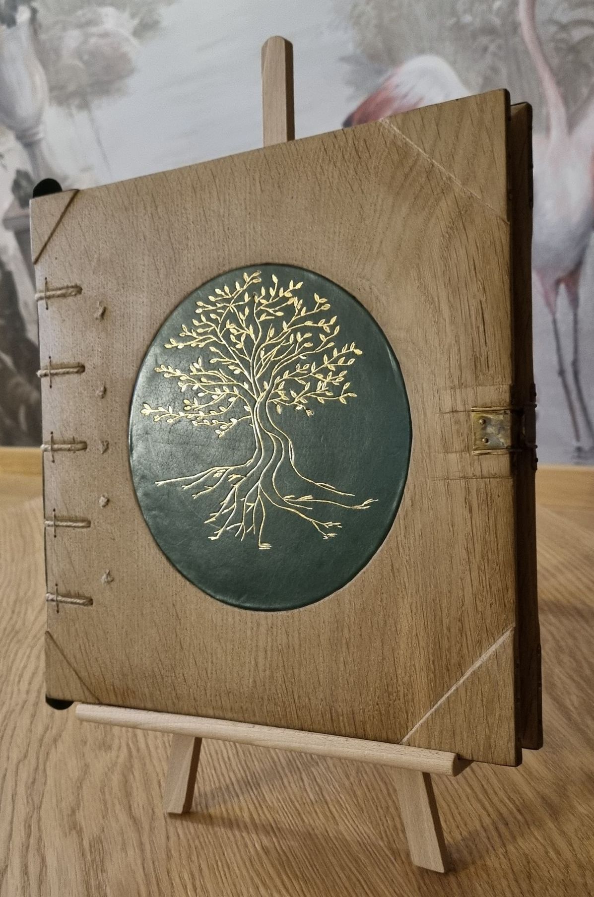 Un livre avec un arbre dessus est posé sur un chevalet en bois.