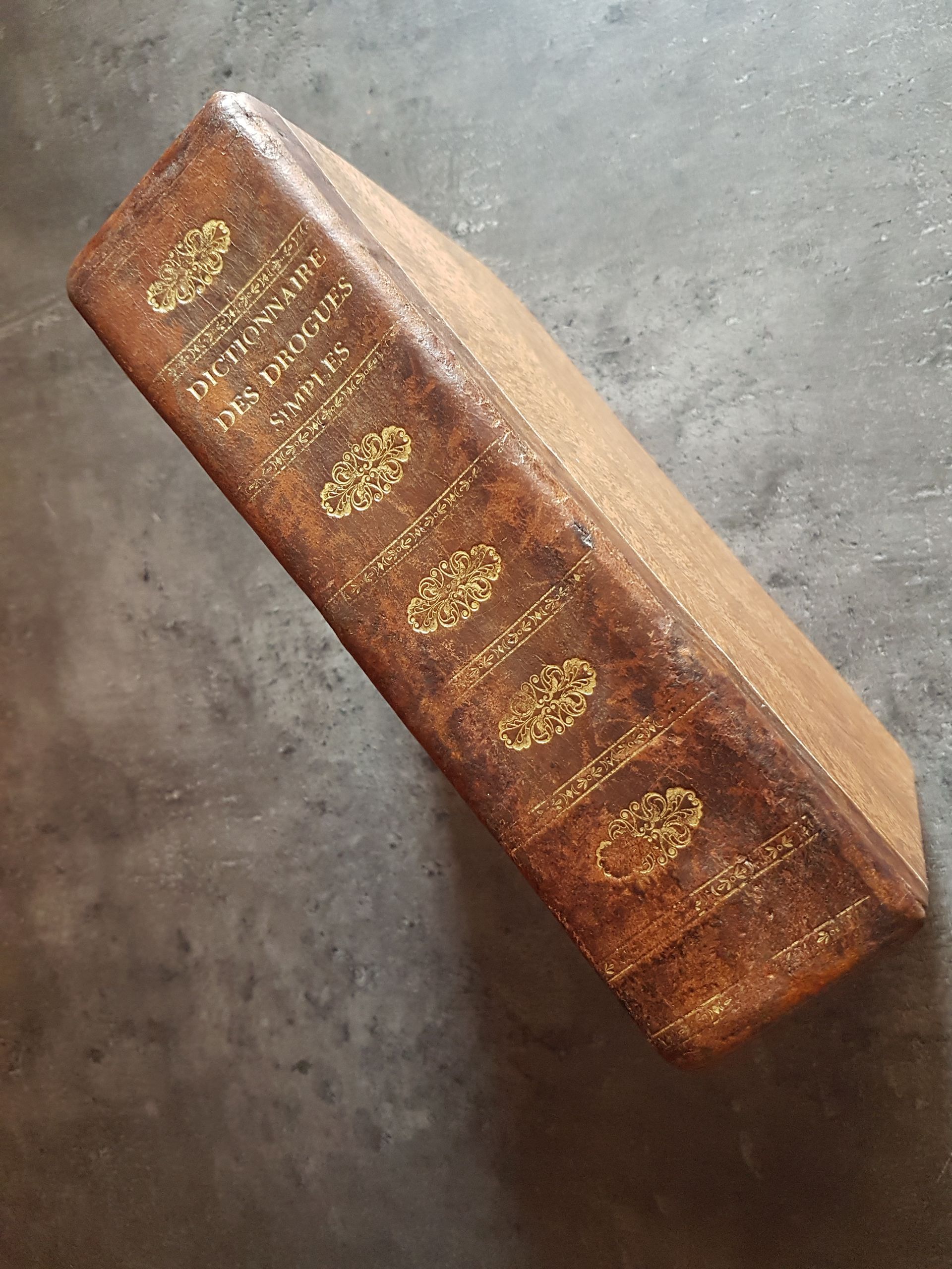 Un livre relié en cuir marron est posé sur une table.