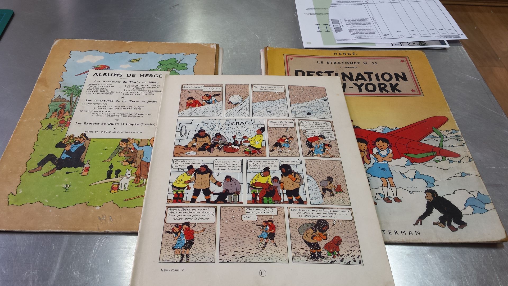 Trois bandes dessinées sur une table dont une intitulée Destination York