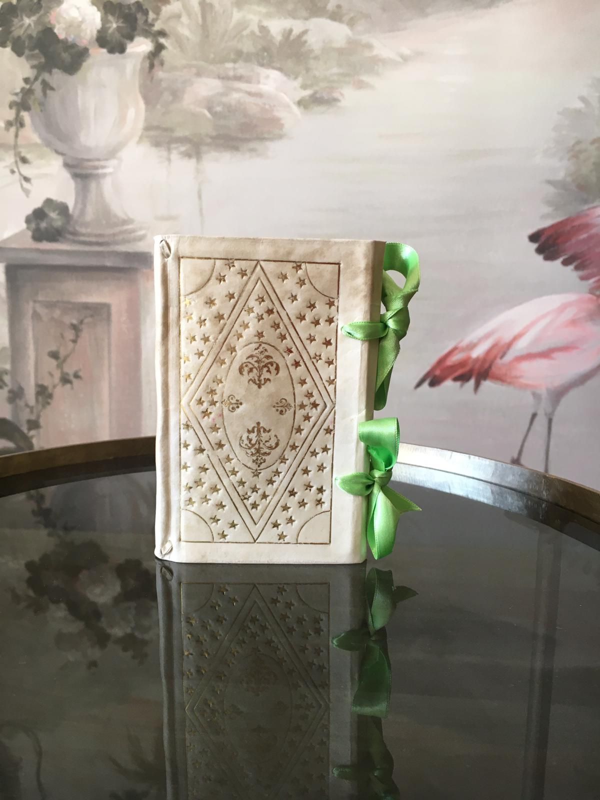 Un livre avec un ruban vert est posé sur une table.