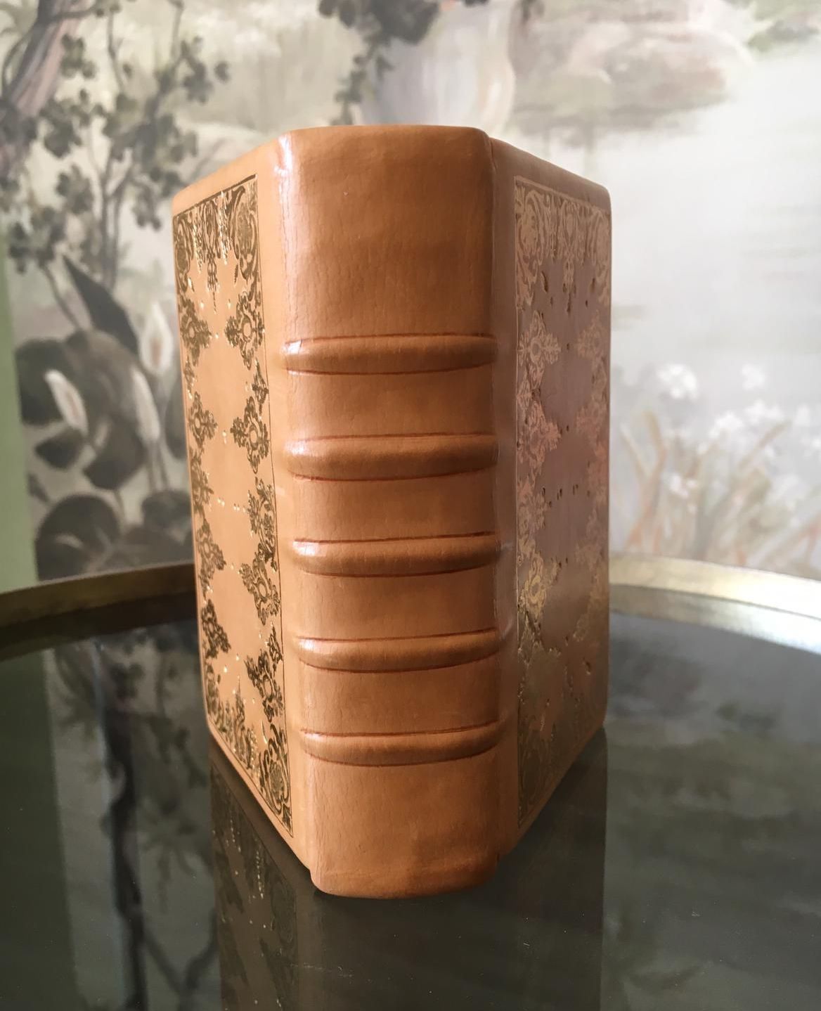 Un livre en cuir marron est posé sur une table en verre.