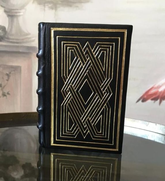 Un livre noir et or est posé sur une table en verre